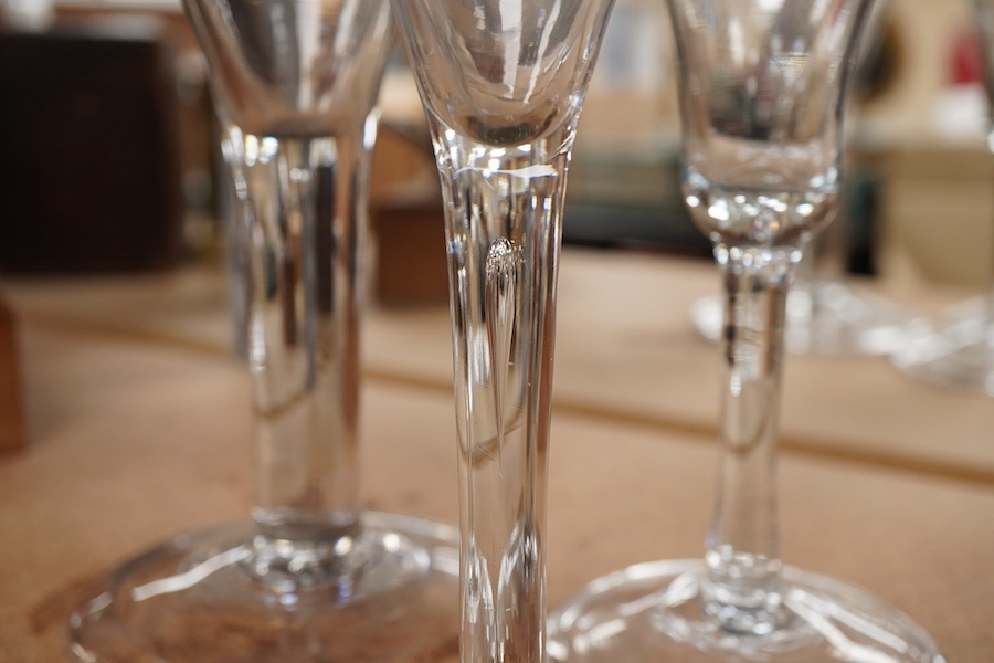 Three late 18th century trumpet glasses, all with plain stems containing tears, tallest 21cm